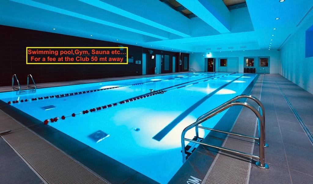 a large swimming pool with blue lighting in a building at Corso Como New Building Apartment in Milan
