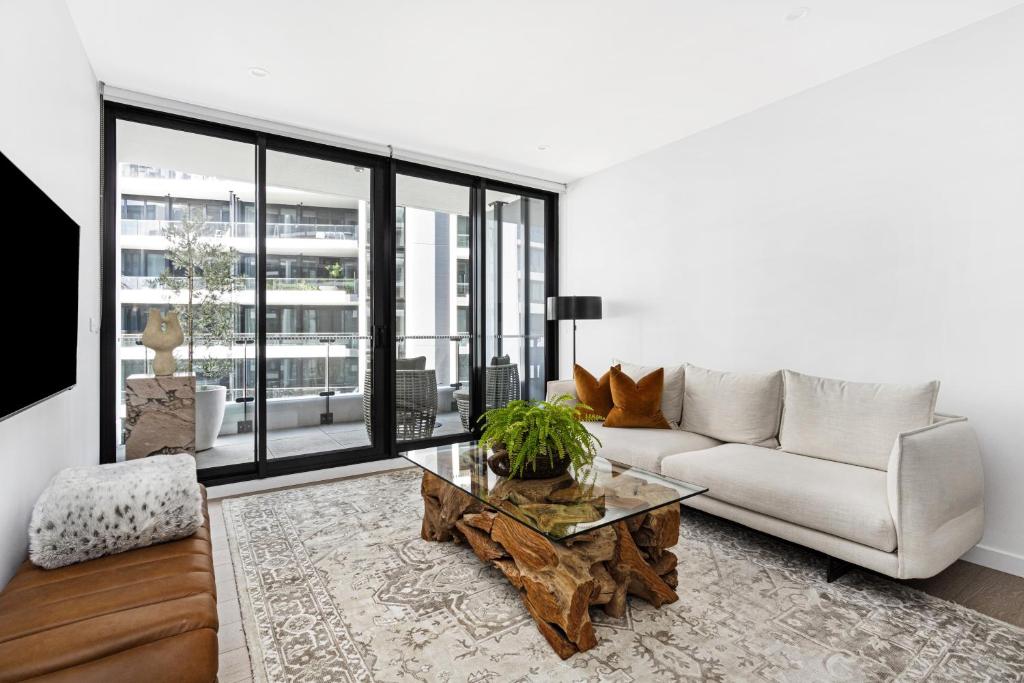 a living room with a couch and a coffee table at Birch Apartments by the Lake in Canberra