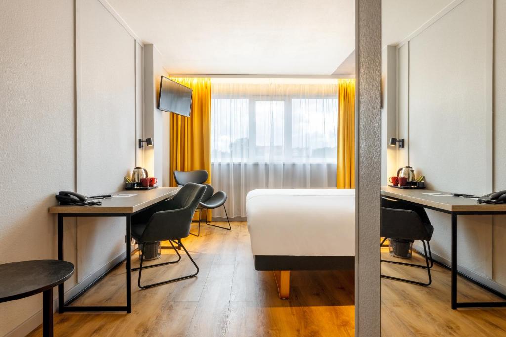 a hotel room with a bed and a desk and chairs at Metropol Hotel in Tallinn