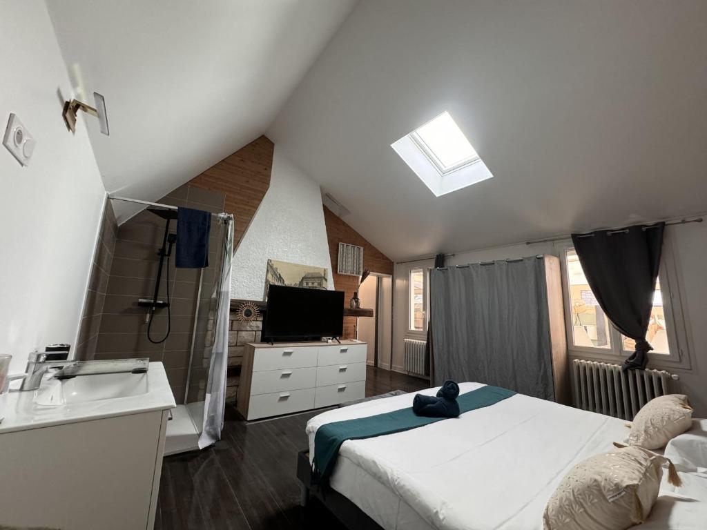 - une chambre avec un lit, un lavabo et une télévision dans l'établissement L Agreable Suite Circuit Reve au Mans, à Écommoy