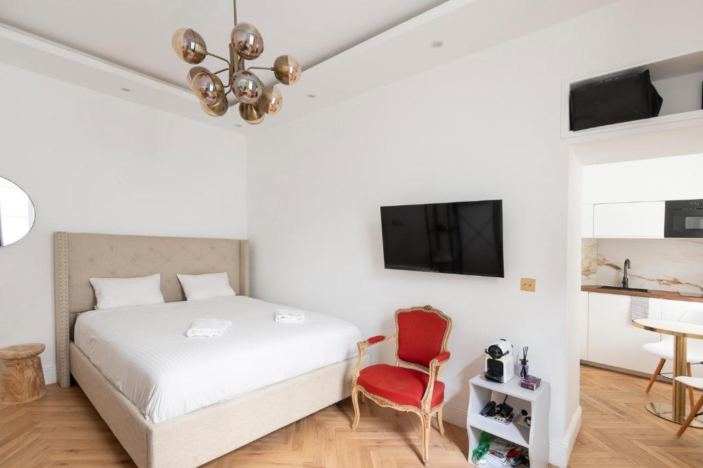 um quarto com uma cama e uma cadeira vermelha em Paris Eiffel em Paris