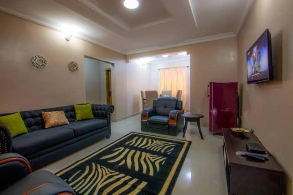 ein Wohnzimmer mit einem Sofa und einem Tisch in der Unterkunft Sidney Apartment in Ilorin