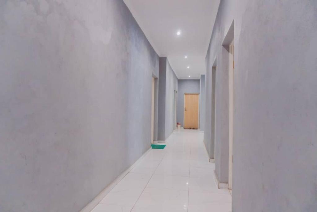 pusty korytarz z białymi ścianami i białymi podłogami w obiekcie Adams lodges Ltd w mieście Mangochi