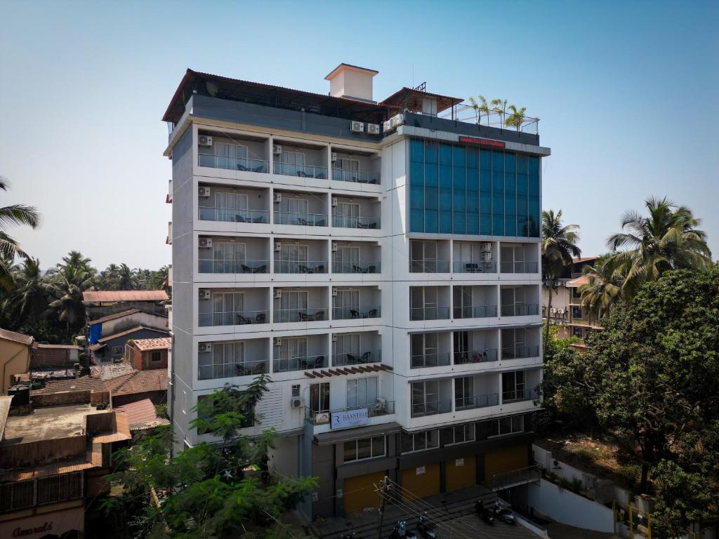 a tall white building in a city at Saikiran Hotel in Mapusa