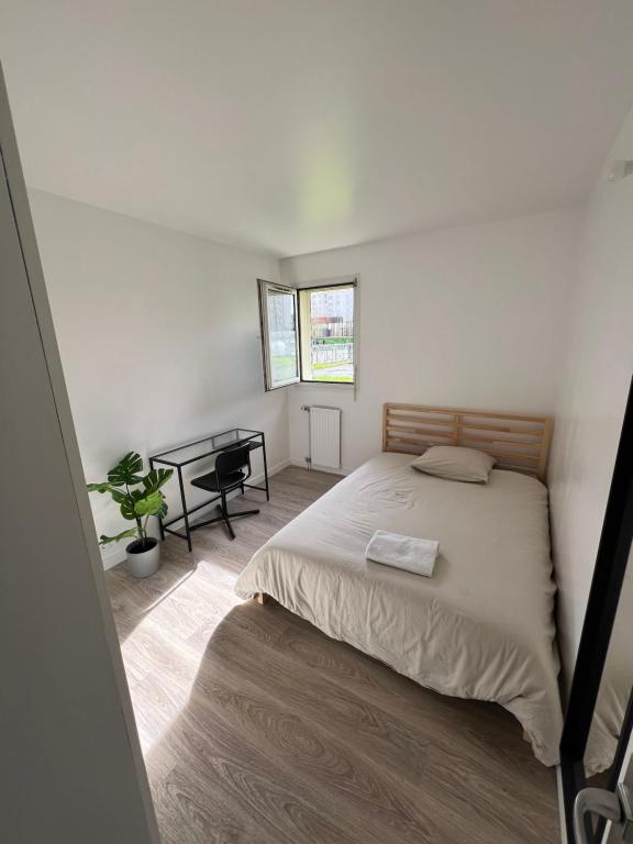 a bedroom with a bed and a table in it at Appartement Dammarie-les-Lys in Dammarie-lès-Lys