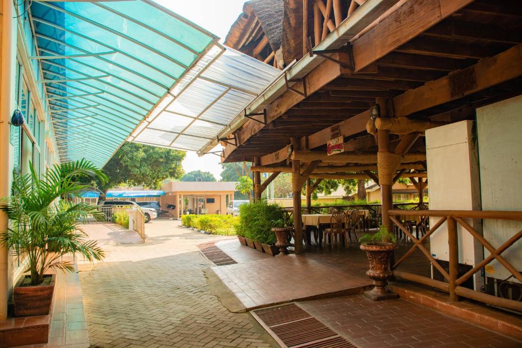 an outdoor patio with awning and tables and chairs at Bomah Hotel Limited in Gulu