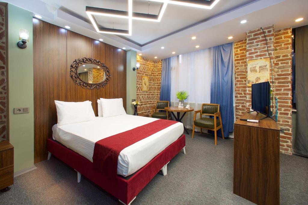 um quarto de hotel com uma cama e uma televisão em Galata By Boss Hotel em Istambul