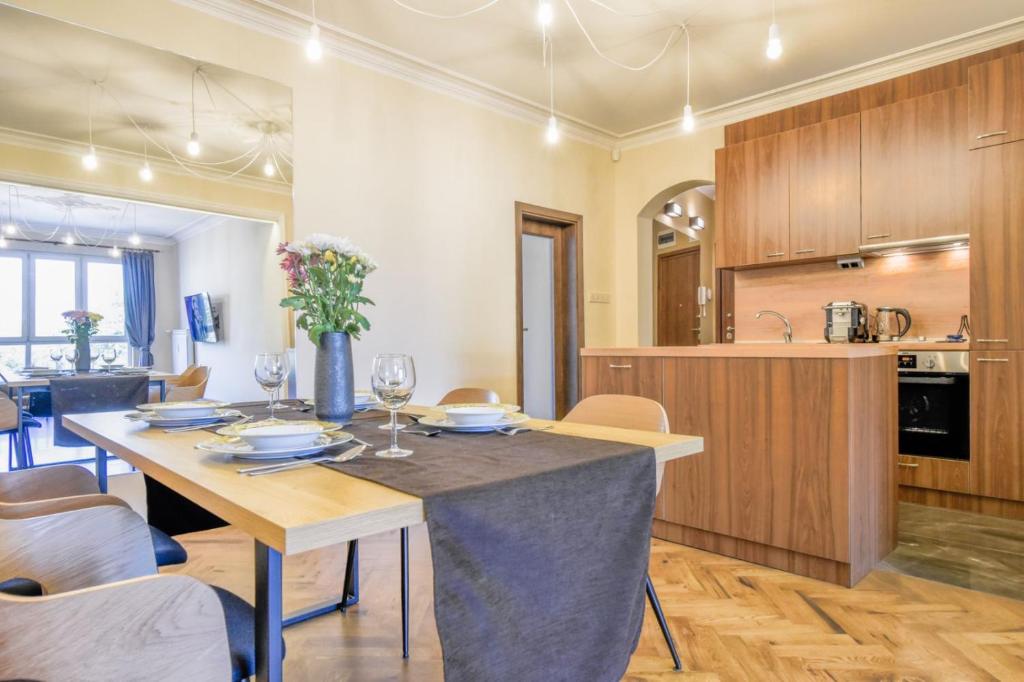a kitchen and dining room with a table and chairs at Stunning 2BDR Condo on Historic Location in Center in Sofia