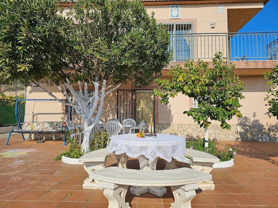 een witte tafel en banken op een binnenplaats bij Apartment mit Bergblickterrasse bei Lloret de Mar in Vidreres