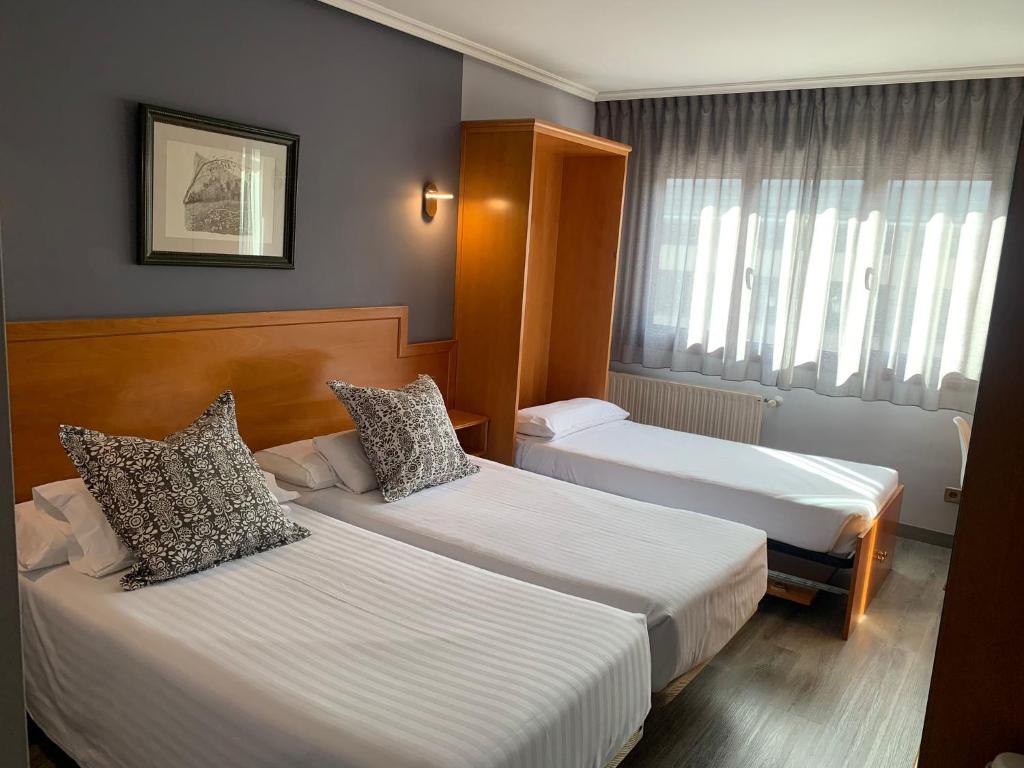 Postel nebo postele na pokoji v ubytování Hotel Carbayon