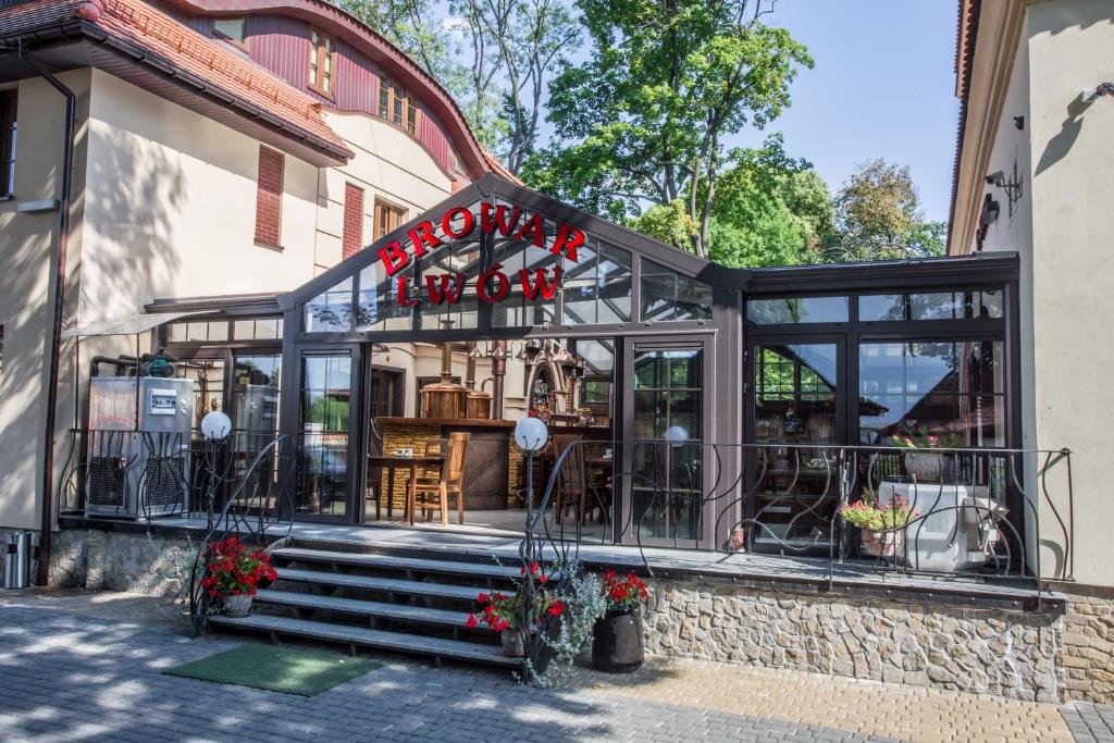 un restaurante con puertas de cristal y flores en la fachada en Hotel Restauracja Browar Lwów w Lublinie, en Lublin