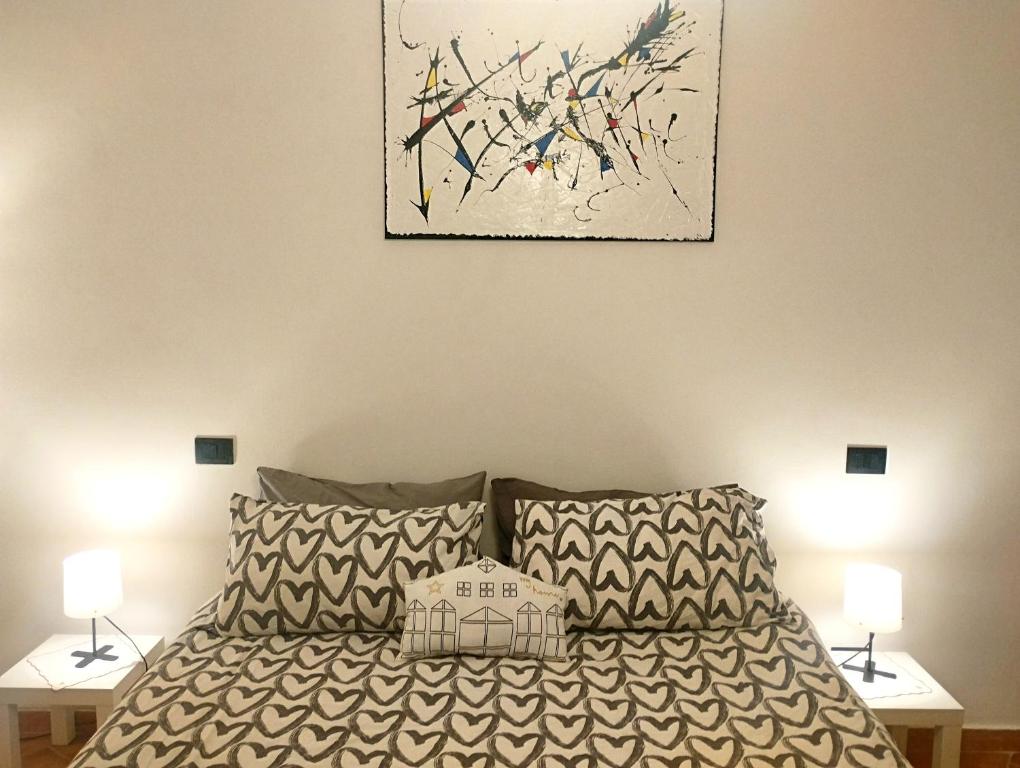 een slaapkamer met een bed met 2 lampen en een schilderij bij OLD TOWN HOUSE LA CORTE Casa Vacanze in Civita Castellana