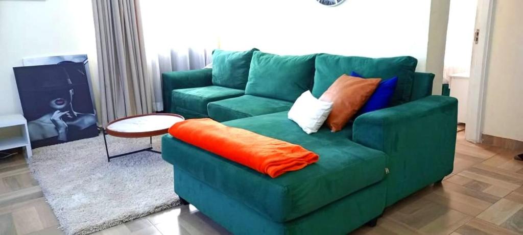 a green couch with pillows on it in a living room at pgs plaz in Nakuru