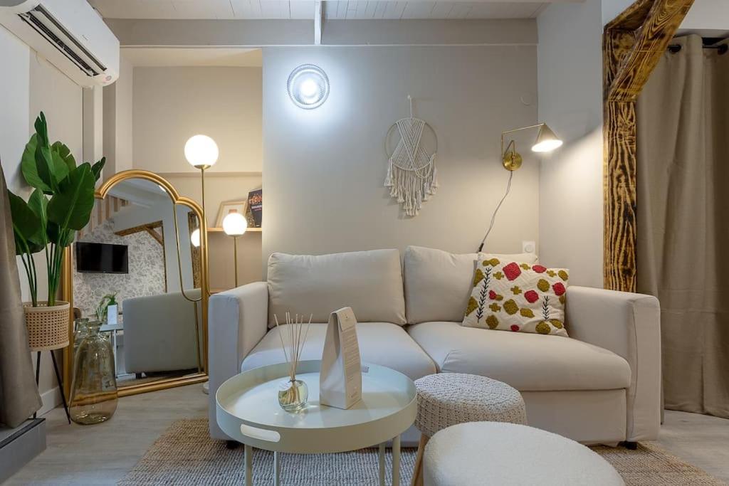 un salon avec un canapé blanc et une table dans l'établissement L'élégance du Capitole, à Toulouse