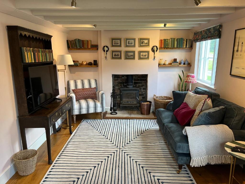 a living room with a couch and a television at Luxury Cottage with Garden in Bredon