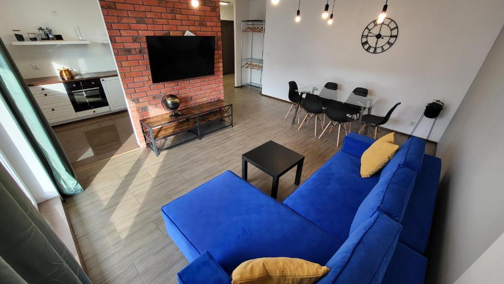 a living room with a blue couch and a kitchen at Angielska 96 in Gdańsk