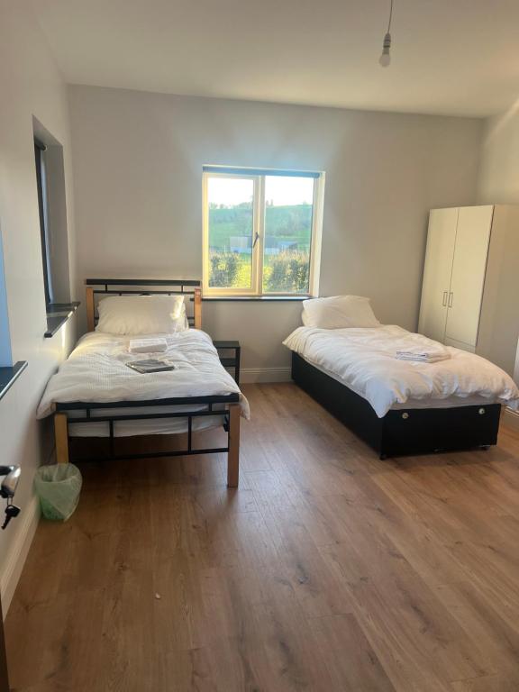 two beds in a room with a window at Willow Valley in Monaghan