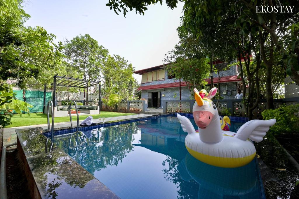 a pool with a swan inflatable duck in the water at EKO STAY- Brickstone Villa in Igatpuri
