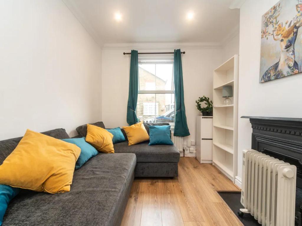 a living room with a couch and a fireplace at Pass the Keys Modernised family-friendly cottage in Surbiton