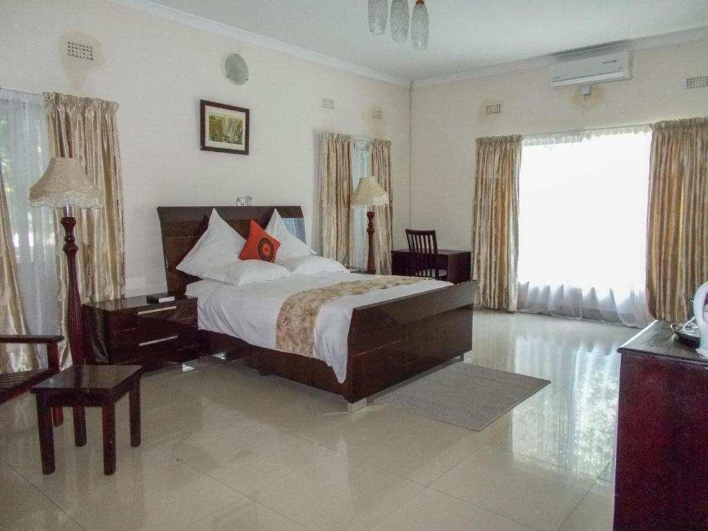 A bed or beds in a room at Waterfalls hotel (Lusaka)