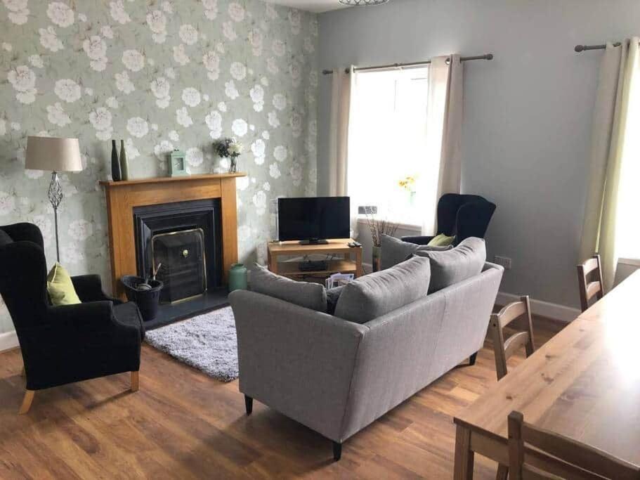 a living room with a couch and a fireplace at Miekle Farm Cottage in Westruther