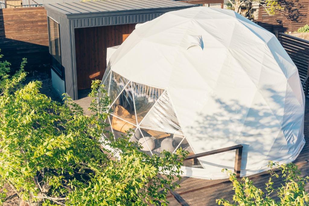 由布市にあるThe Village 由布院 温泉グランピングの家屋の上に座るドームテント