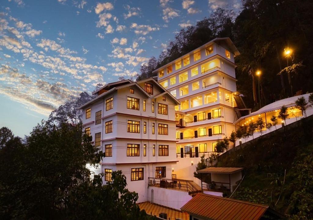 een groot wit gebouw aan de zijkant van een heuvel bij Voyage Dreamvilla Retreat in Pelling