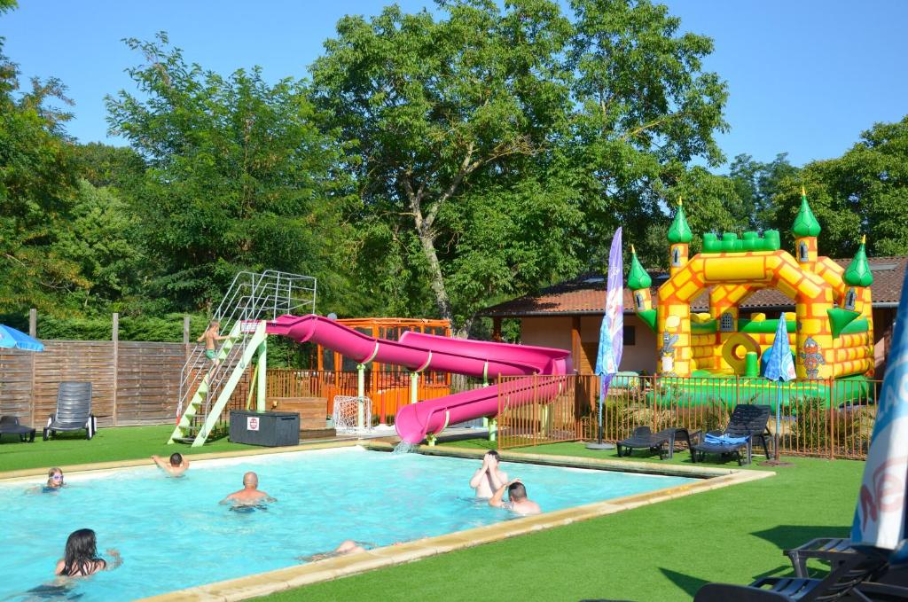 a group of people in a pool with a water park at Flower Camping Les Mijeannes in Rieux-de-Pelleport