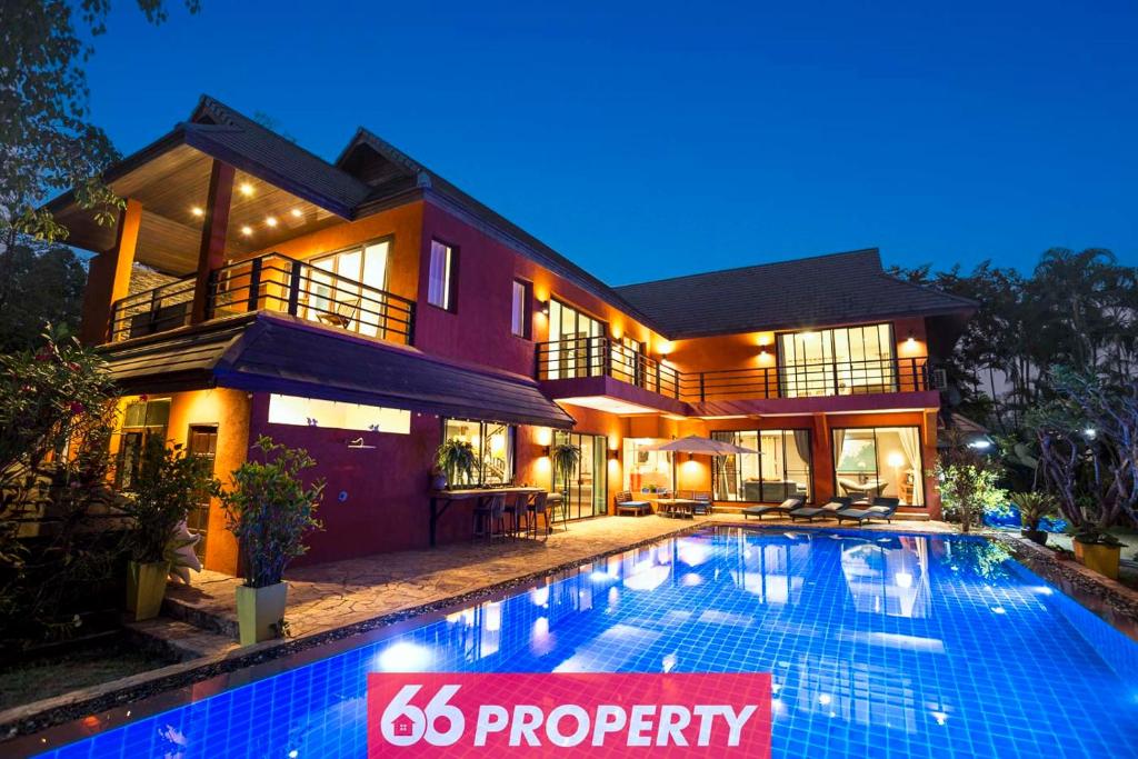 a house with a swimming pool in front of it at THE ONE VILLA in Chiang Mai
