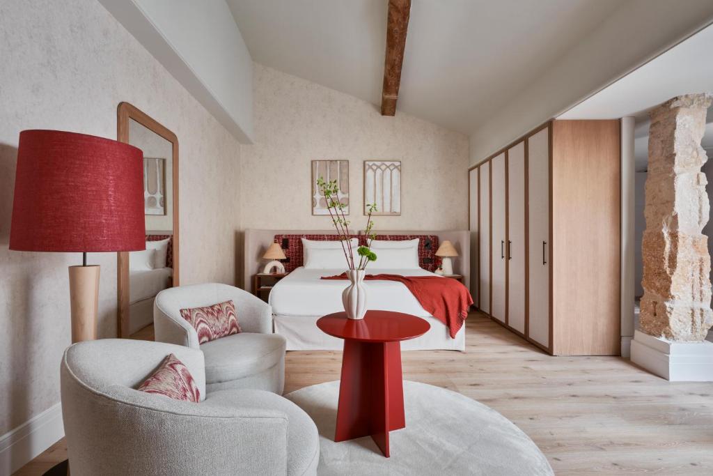 1 dormitorio con 1 cama, mesa roja y sillas en Boutique Hotel Posada Terra Santa en Palma de Mallorca