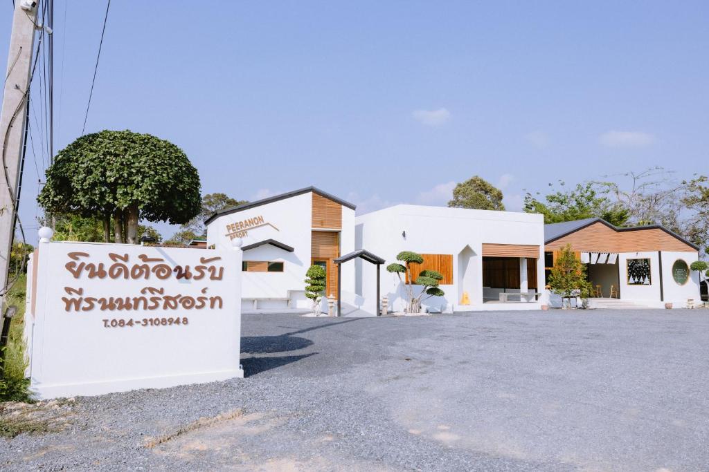 Peeranon Resort في Ban Nong Khiam: مبنى فيه لافته امام شارع