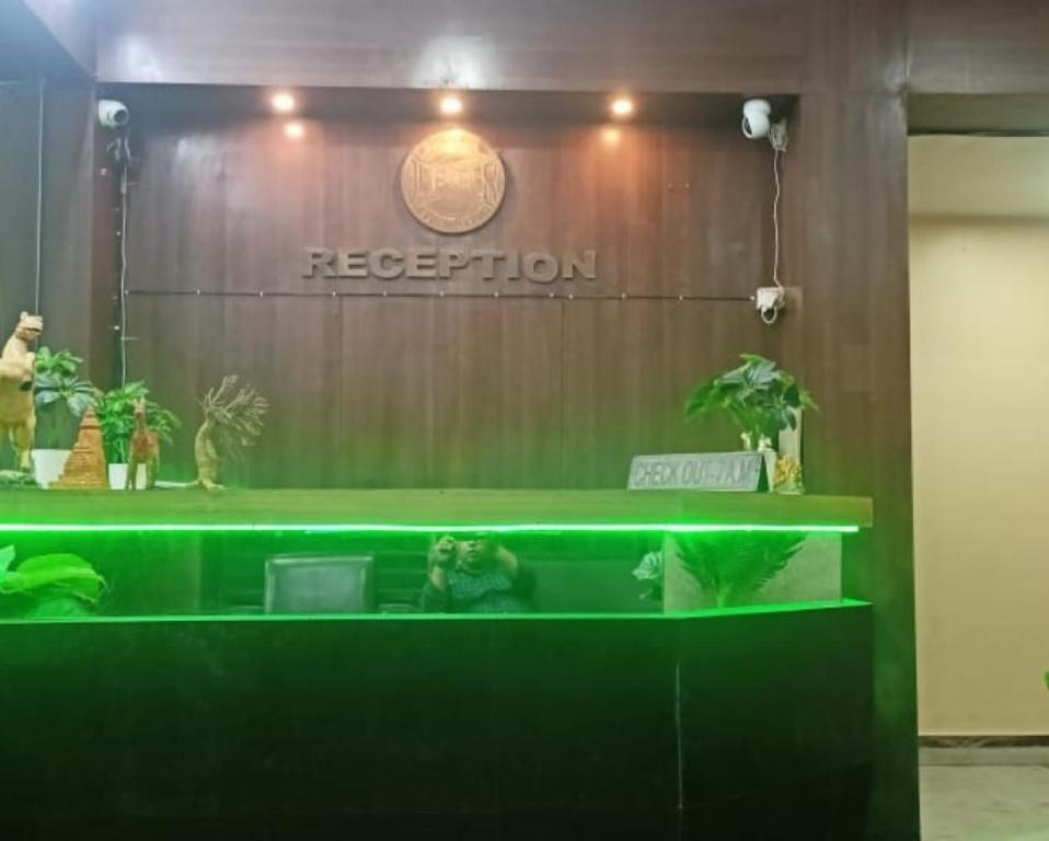 a reception desk with a green counter in a room at Jupiter Beach Resort , Puri in Puri
