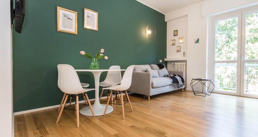 - un salon avec une table, des chaises et un canapé dans l'établissement ALTIDO Delightful Flats Near CityLife District, à Milan