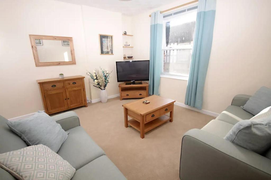 a living room with a couch and a tv at 28A Benedict Street in Glastonbury