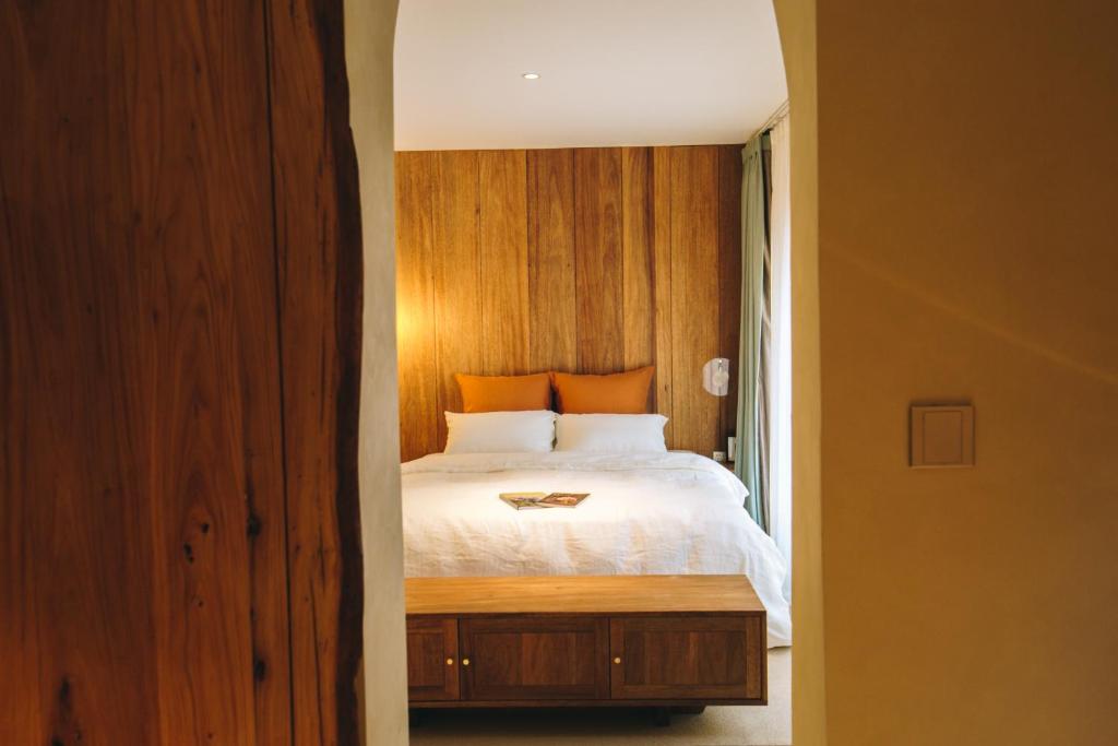 sypialnia z łóżkiem z drewnianą ścianą w obiekcie 禾煦的家-和煦 HX house w mieście Qingdao