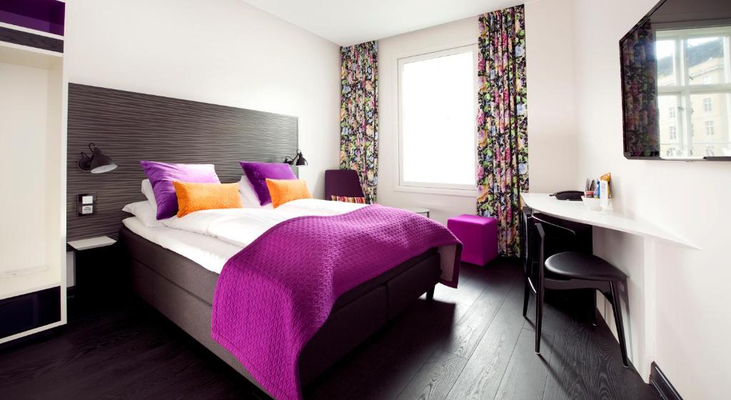a bedroom with a bed with a purple blanket on it at Hotel No13 in Bergen