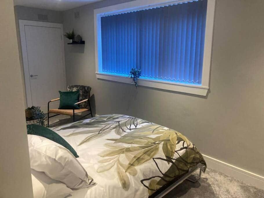 a bedroom with a bed and a blue window at Teviot View in Hawick