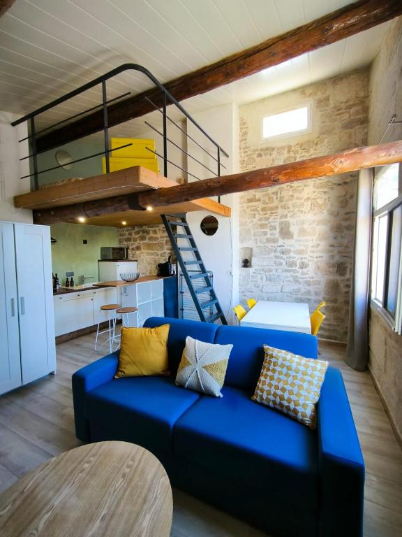 un salon avec un canapé bleu et une mezzanine dans l'établissement Place du marche - Premiere conciergerie, à Nîmes