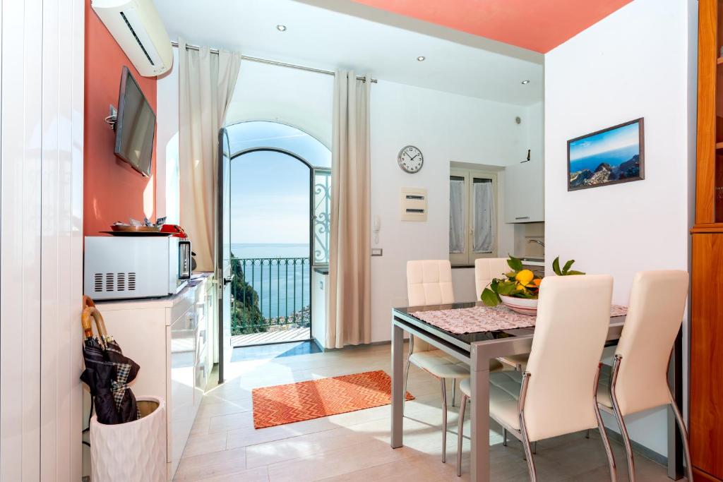 a dining room with a table and a view of the ocean at Il Paradiso sul Mare Apartment in Scala