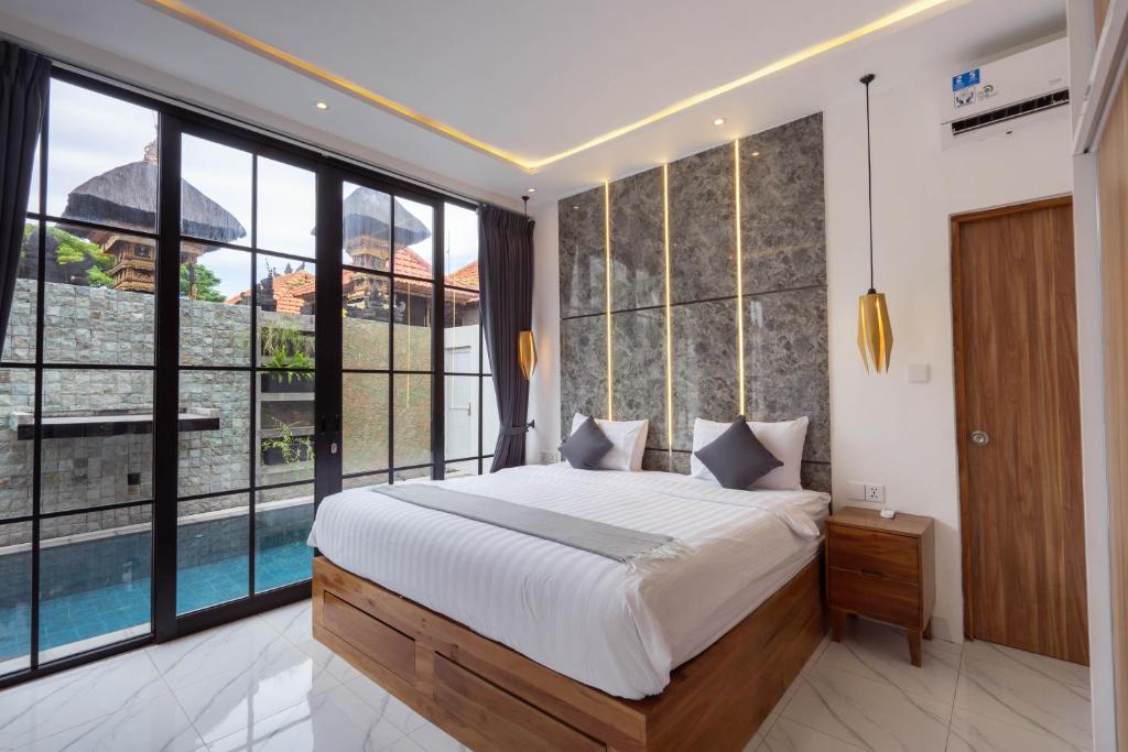 1 dormitorio con 1 cama grande y ventanas grandes en The Lavana Seminyak Loft 360 - 1 Bedroom Villa with Private Pool, en Seminyak