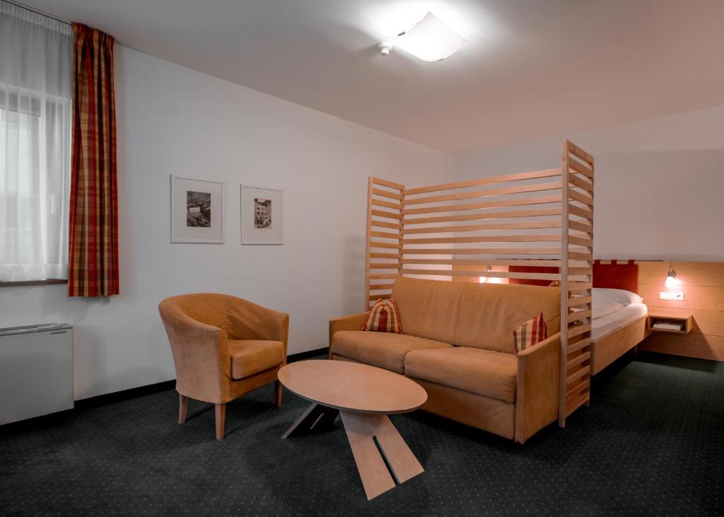 a hotel room with a couch and a bed at Hotel Figl ***S in Bolzano