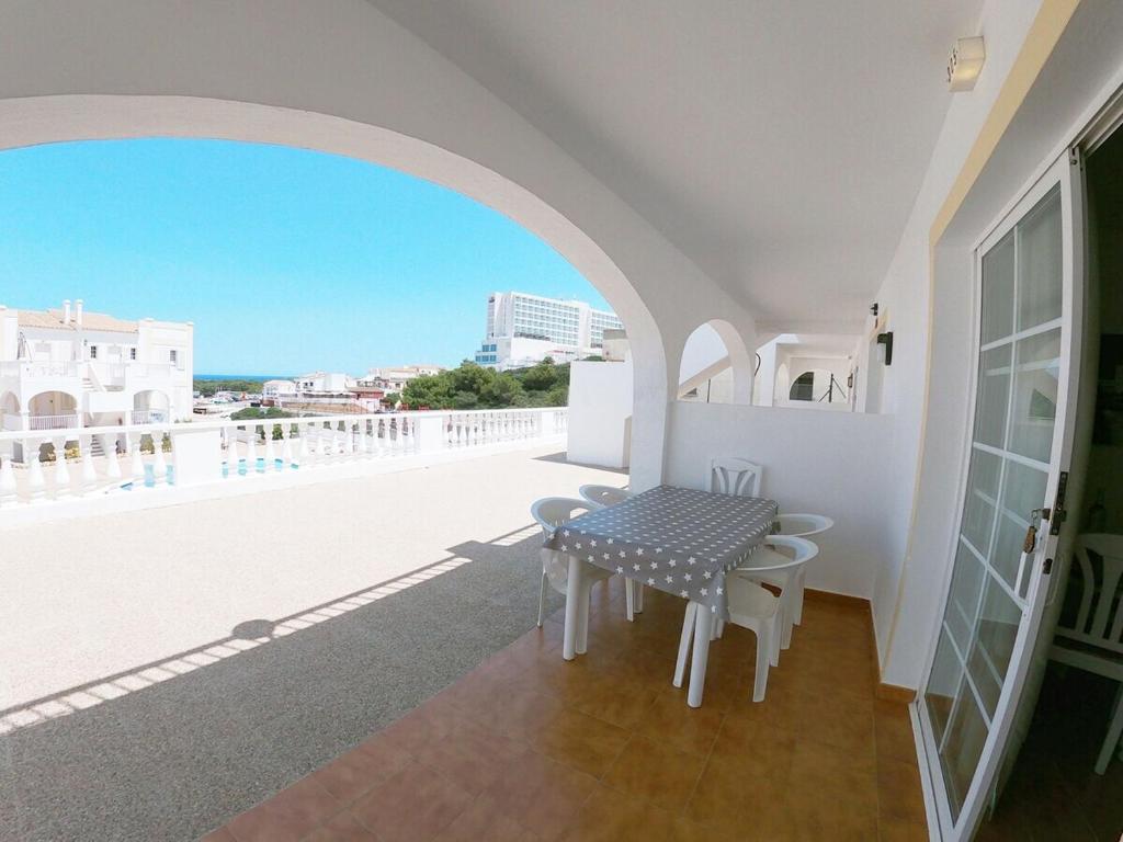 balcón con mesa y vistas al océano en Apartamento 305 Castell sol CB, en Arenal d'en Castell