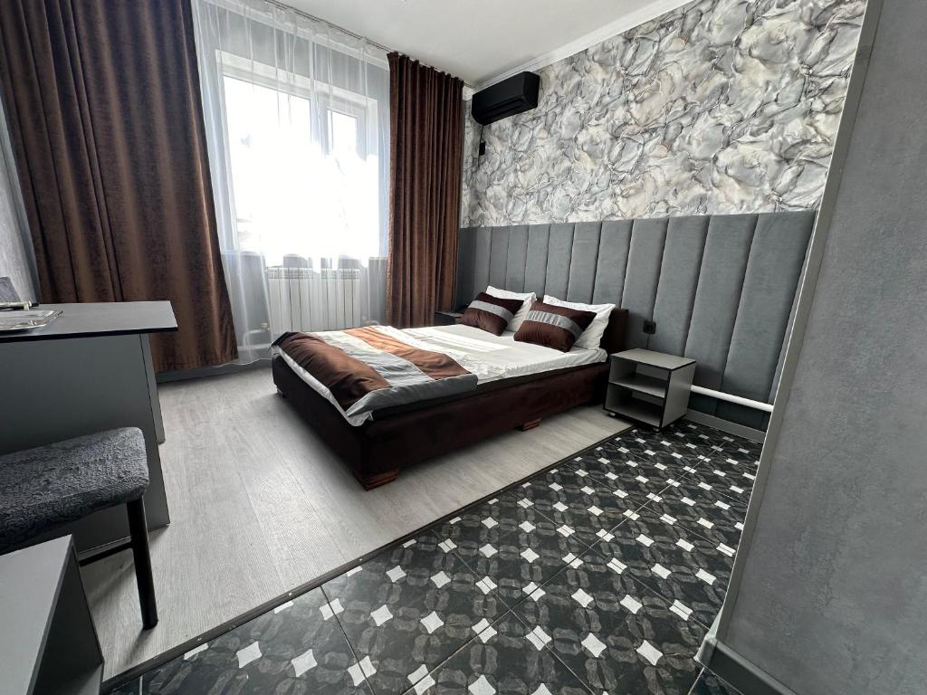 a bedroom with a bed and a large window at Faeton in Almaty