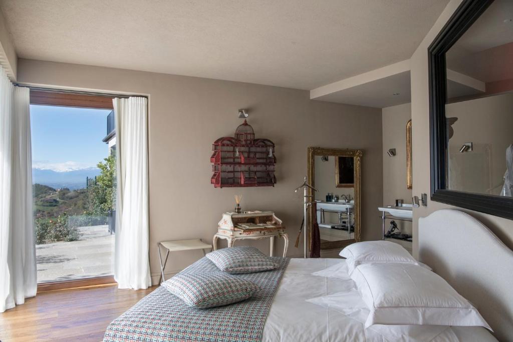 ein Schlafzimmer mit einem Bett und einem großen Fenster in der Unterkunft Relais Le Due Matote in Bossolasco