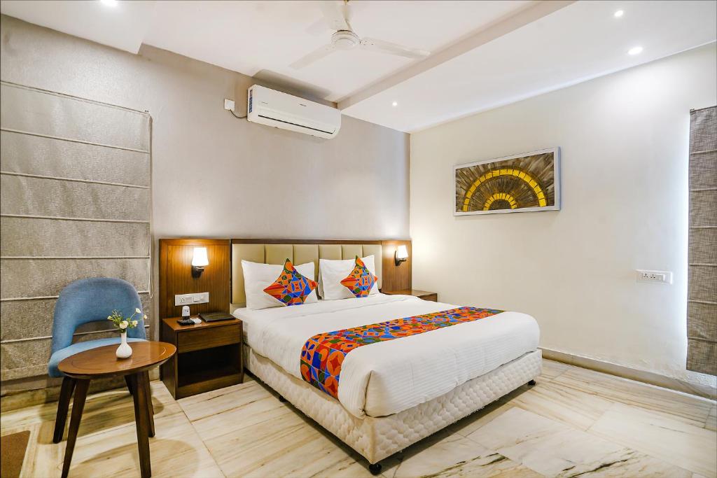 a bedroom with a bed and a desk and a chair at FabHotel Prime D Dev in Vijayawāda