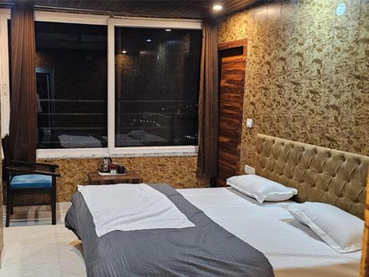 a bed in a room with a window and a bed sidx sidx sidx at Hotel Mussoorie Gold Mary in Mussoorie