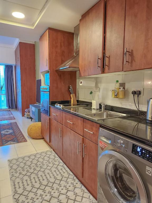 eine Küche mit Waschmaschine in der Unterkunft Rustic Elegance By The Lake Studio Cabin In Jlt in Dubai