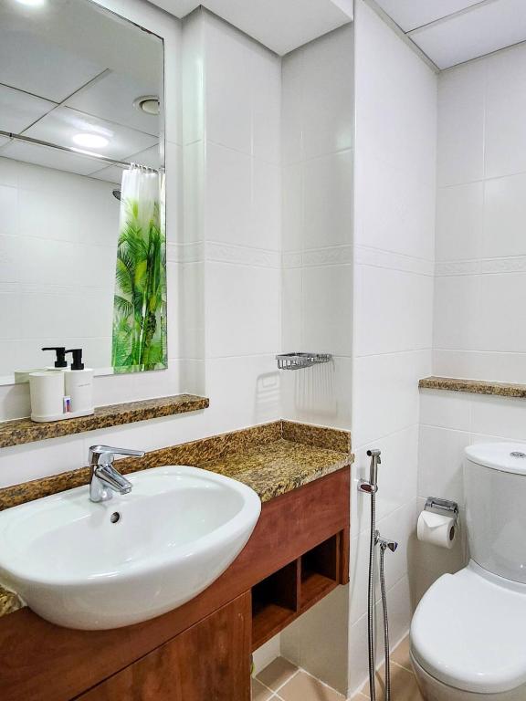 a white bathroom with a sink and a toilet at Rustic Elegance By The Lake Studio Cabin In Jlt in Dubai