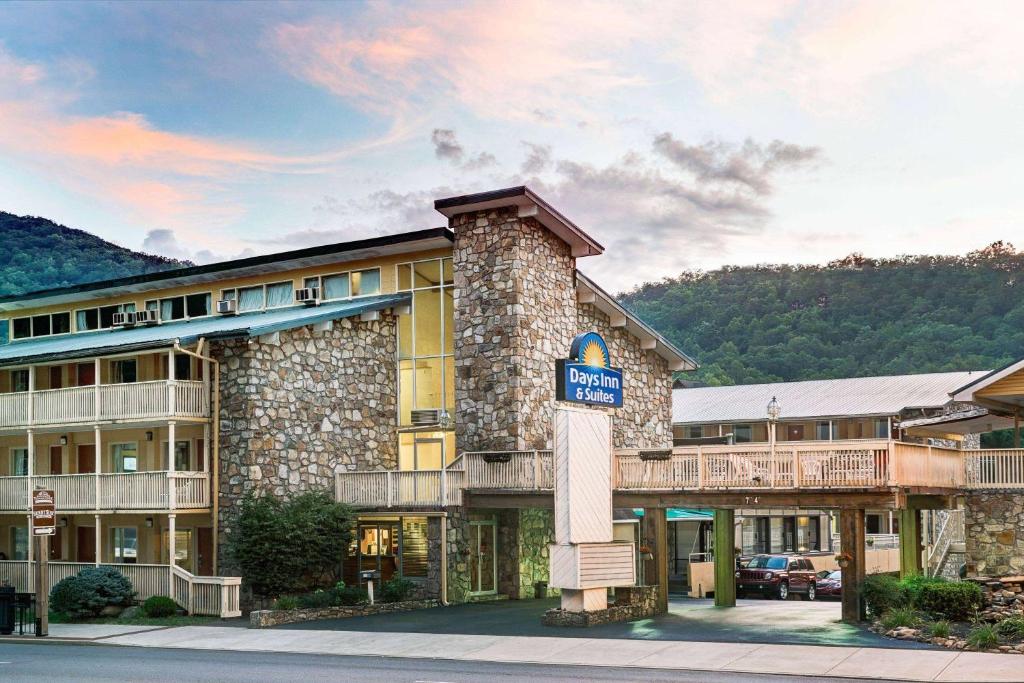 a hotel with a sign in front of it at Days Inn & Suites by Wyndham Downtown Gatlinburg Parkway in Gatlinburg