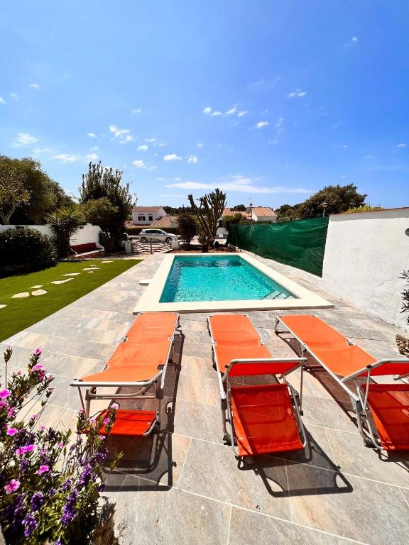 una piscina con tumbonas y una piscina en Casa a pocos minutos de la playa de Cala Galdana, en Cala Galdana